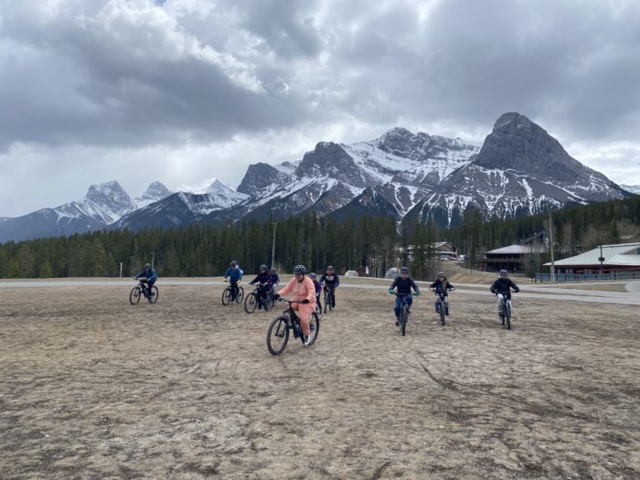 Girls mountain biking in front of mountains