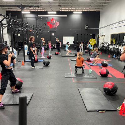 Group of girls in fitness room lifting kettlebells
