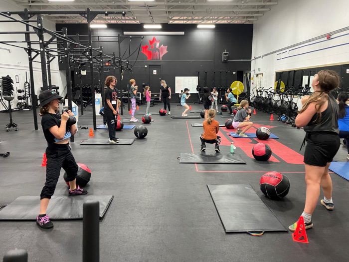 Group of girls in fitness room lifting kettlebells