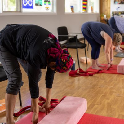 Three Women stretching forward during a yoga class