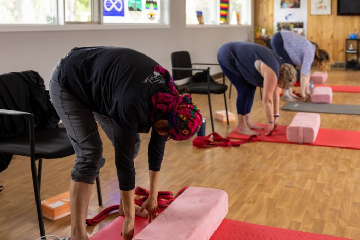 Three Women stretching forward during a yoga class