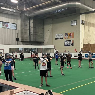 Group of girls practicing indoor box lacrosse.