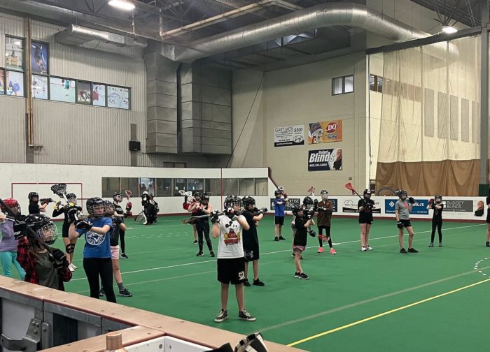 Group of girls practicing indoor box lacrosse.