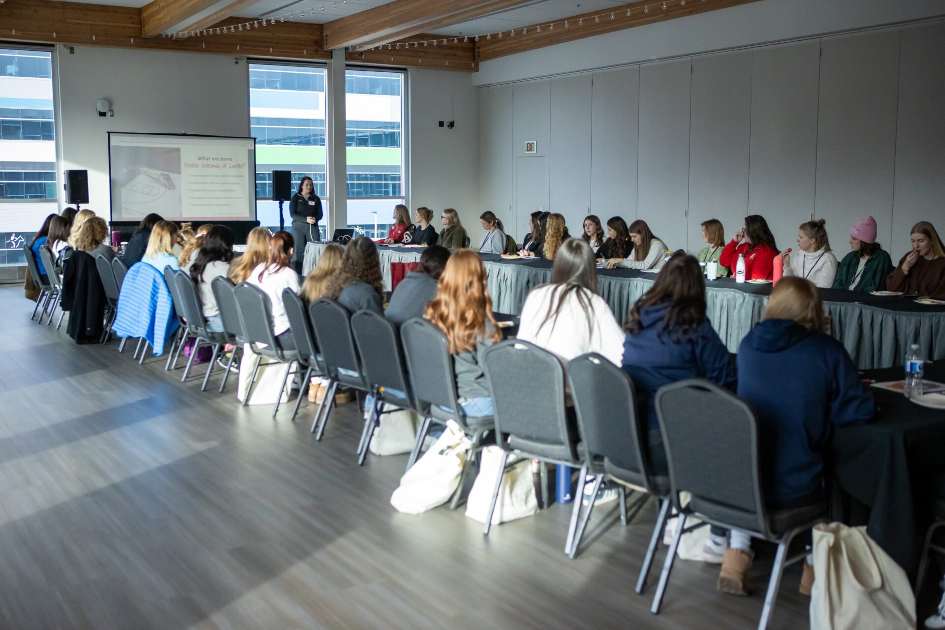 Group of women at tables at a conference.