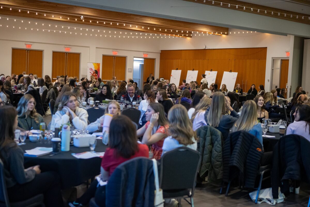 Group of women at a table at a conference.