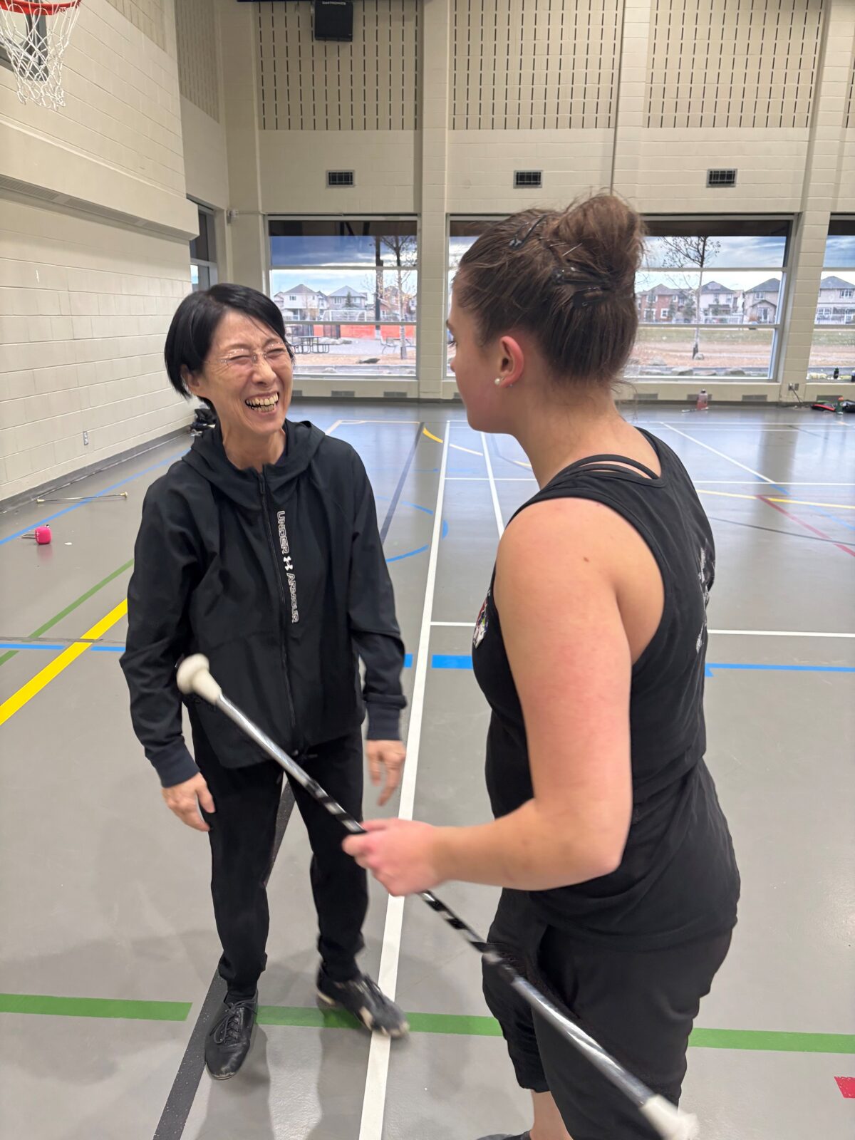 Coaches teaching a woman holding a baton