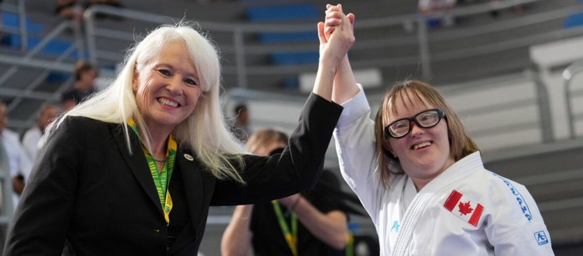 Women Karate Coach holding up the arm of a youth girl participant