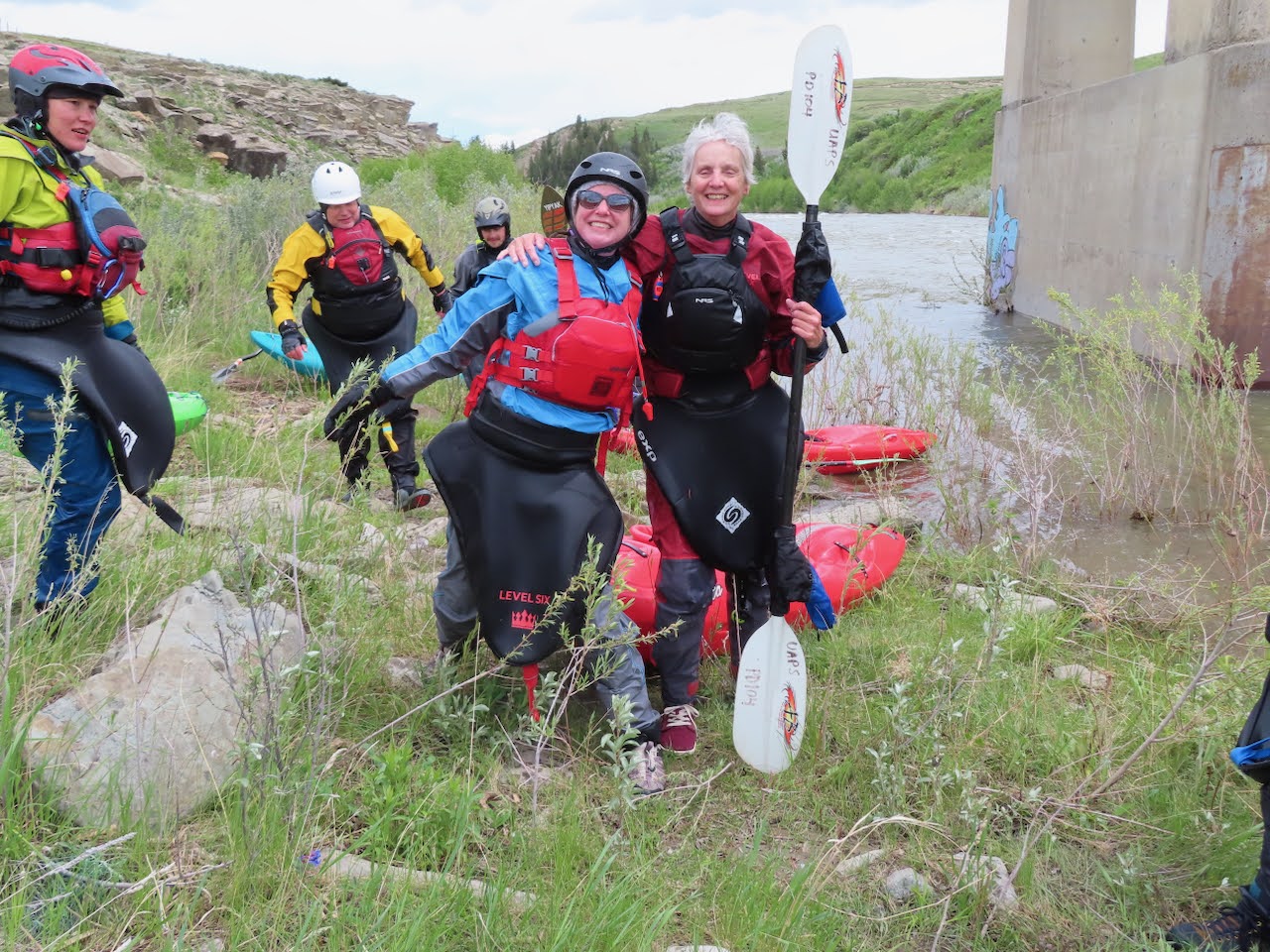 Two women in kayak gear by the river.